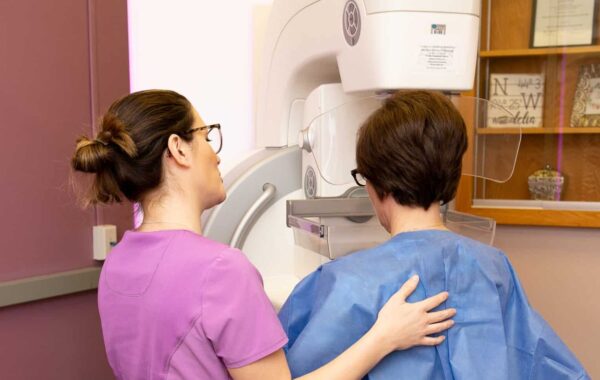 Madelia Health caregiver and patient in front of mammography machine.
